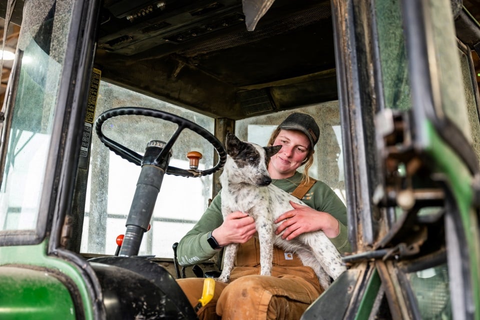 Emily Mullen with dog in cab of tractor