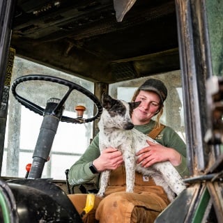 Emily Mullen with dog in cab of tractor