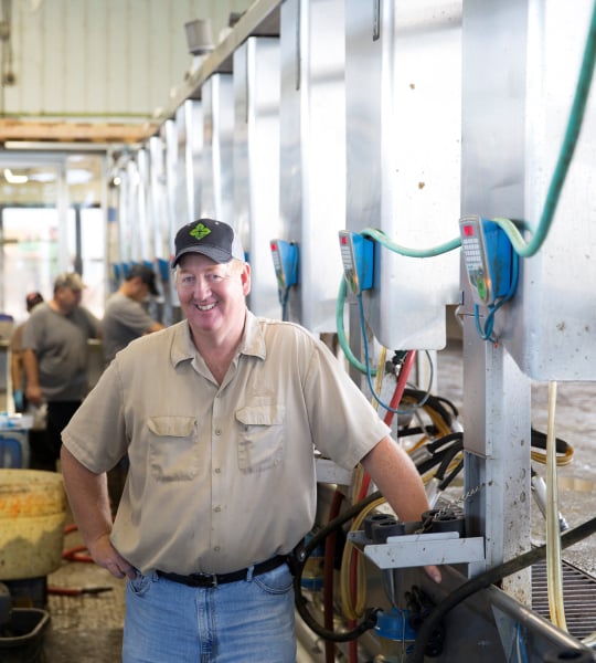 Man standing in milking parlor.