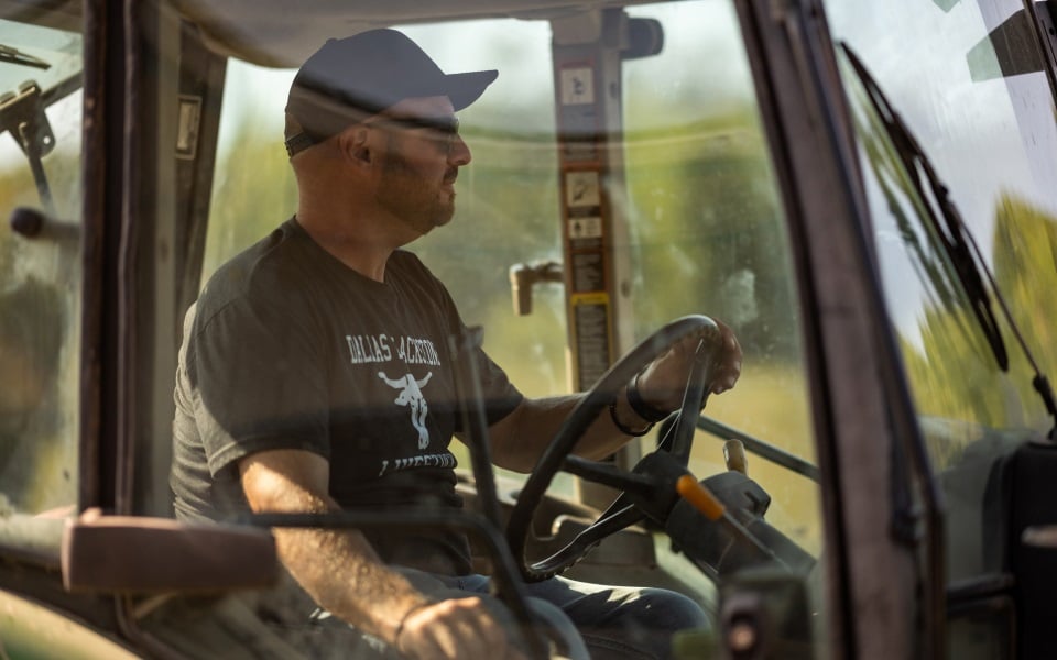 Man driving tractor who receives patronage from Farm Credit Mid-America.