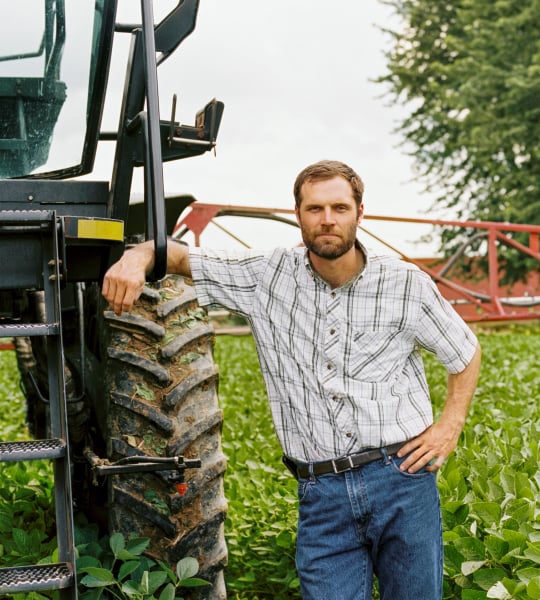 Man standing next to sprayer.