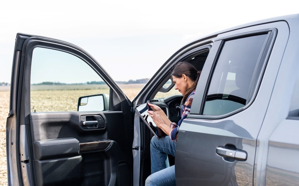 Woman checks her tablet in a truck.